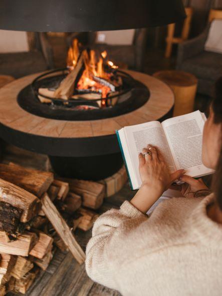 reading the bible in front of a fireplace 
during stress awareness month
